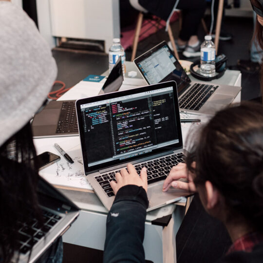 three women looking at a computer screen