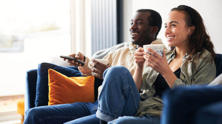 two people sitting on a couch watch CTV